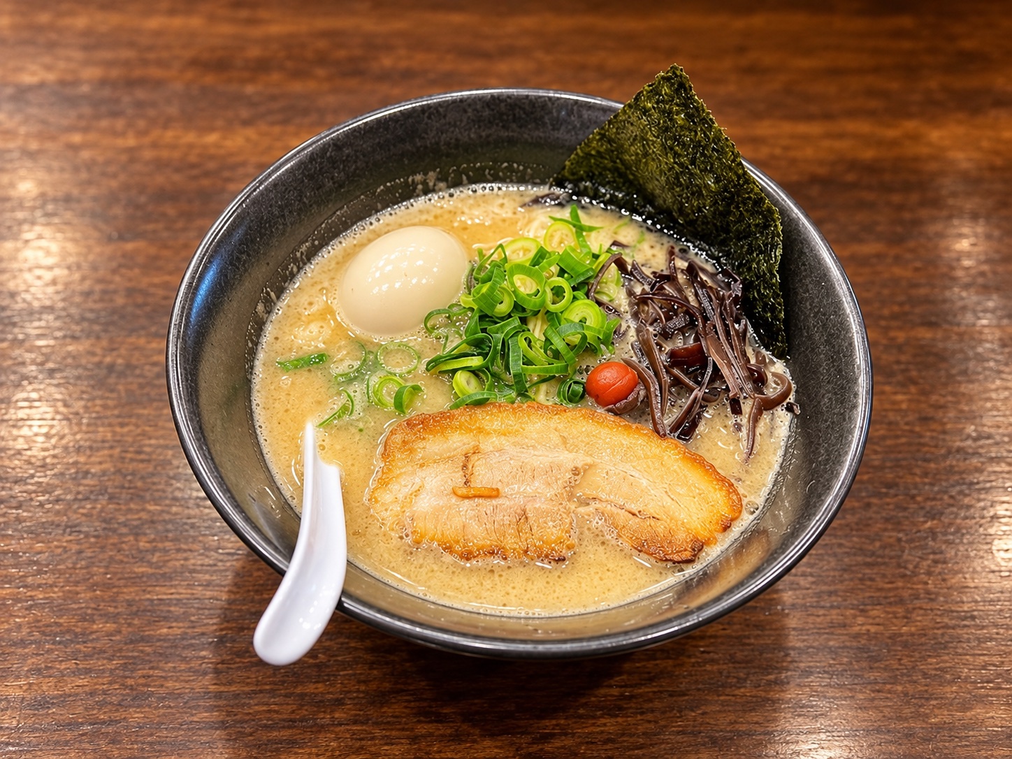チャーシュー、青ねぎ、きくらげ、味玉を整えて盛り付けた平九郎らーめんのイメージ