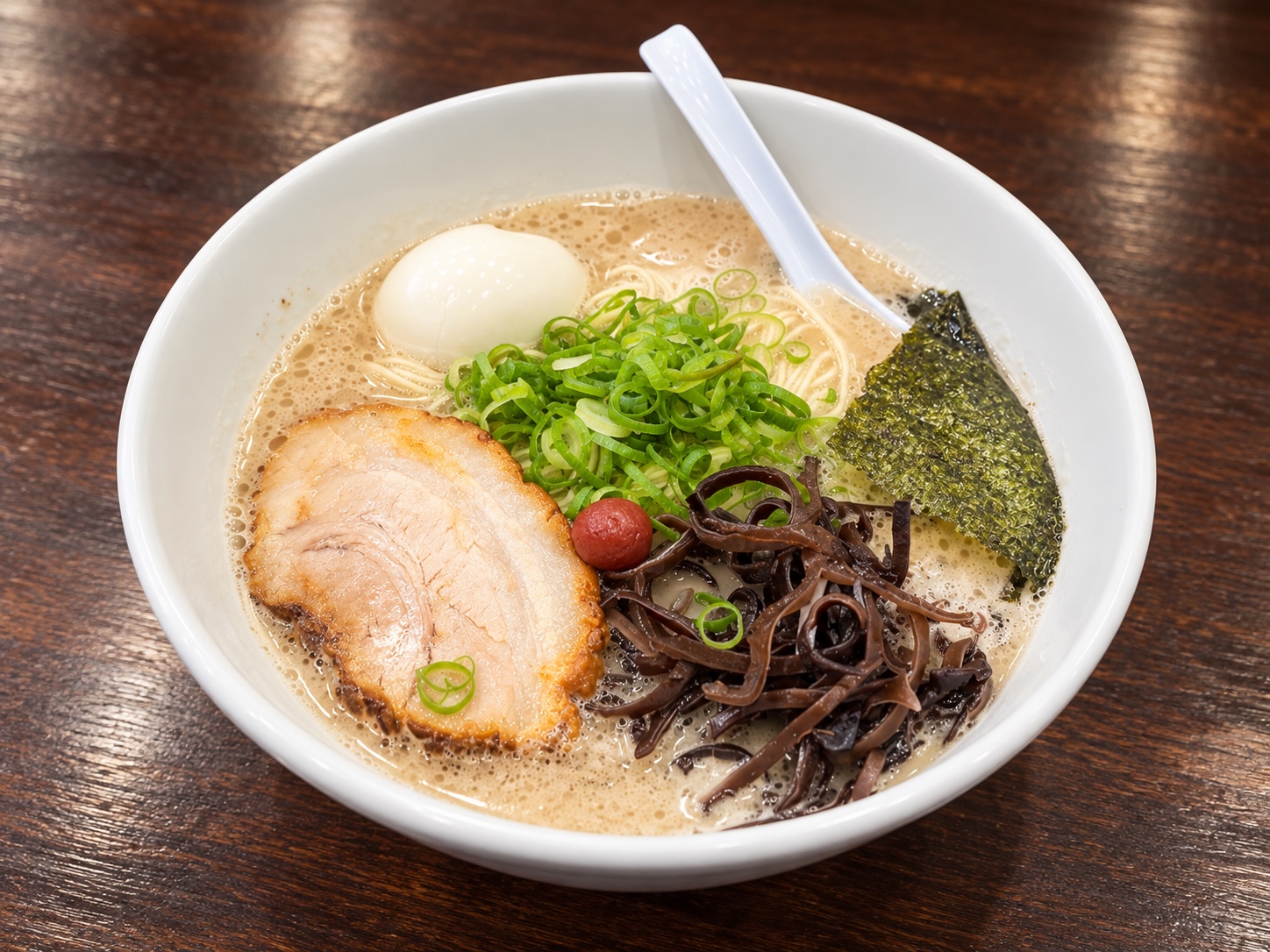 チャーシュー、味玉、青ねぎ、きくらげを盛り付けた平九郎R 春日部店の豚骨ラーメンのイメージ