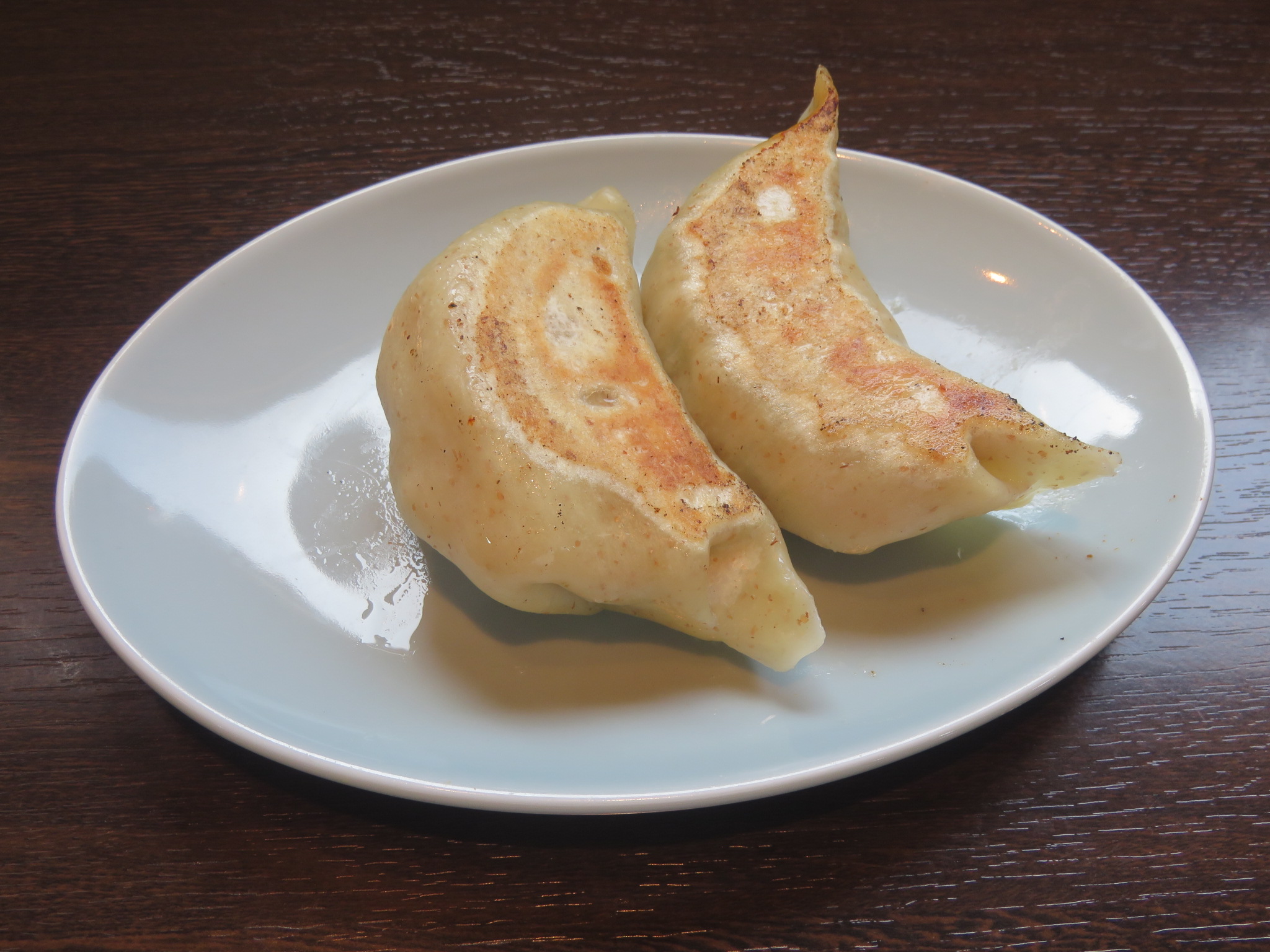 餃子のしのちゃんの白い皿に盛られた大きな焼き餃子